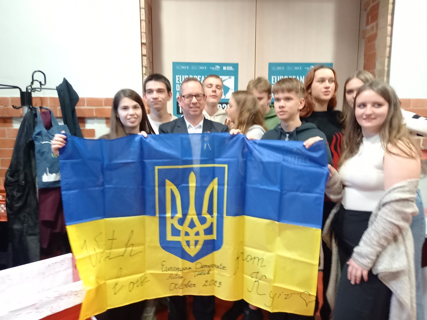 Herr Igel und die Teilnehmenden halten die ukrainische Fahne hoch