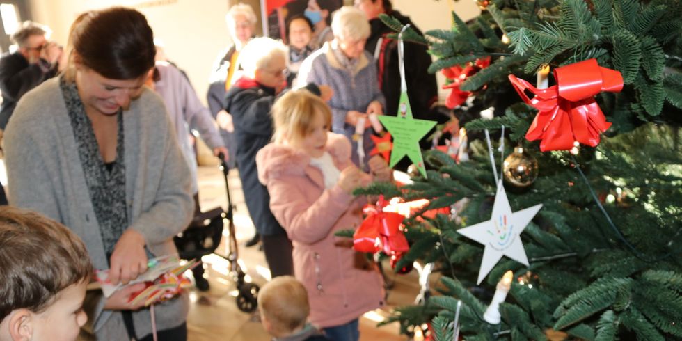 Der Wunschbaum wird mit den Sternen von Kindern und Senioren geschmückt.