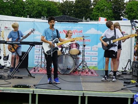 Eine Gruppe junger Musiker mit Gitarren und Schlagzeug auf der Bühne