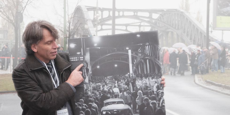 Hans Martin Fleischer mit seinem Foto vor der Brücke an der Bornholmer Straße