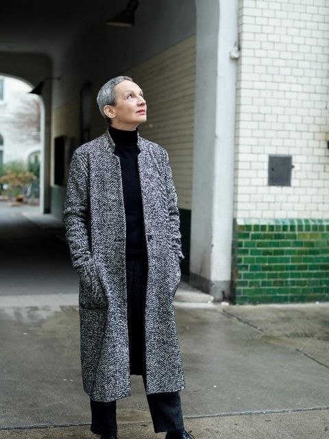 Foto der Autorin Marion Brasch, die mit einem grauen Mantel in einem Hinterhof steht. 