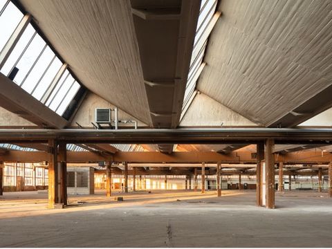 Weiter Blick durch eine lichtdruchflutete leere Lagerhalle