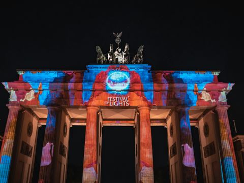 Das Brandenburger Tor wird mit bunten Lichtern angestrahlt.