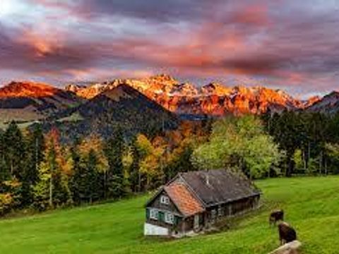 Blick in das Appenzeller Land mit Haus auf der Wiese und Blick auf Wald und Gebirge