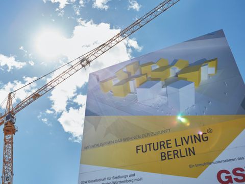 Ein Kran und ein Bauschild für Future Living Berlin