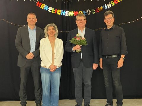 Bildvergrößerung: Gruppenbild mit einem Mann mit Blumenstrauß und drei weiteren Personen