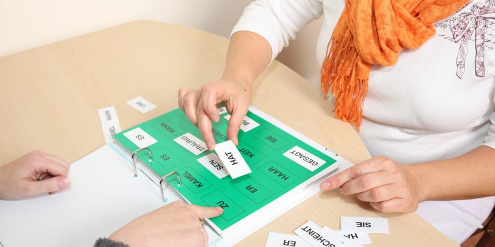Ein Patienten übt in der Praxis eines Logopäden mit Kärtchen auf denen einzelne Worte stehen