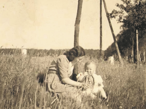 Bildvergrößerung: Eine Mutter und ihr Kind sitzen in einem Feld.