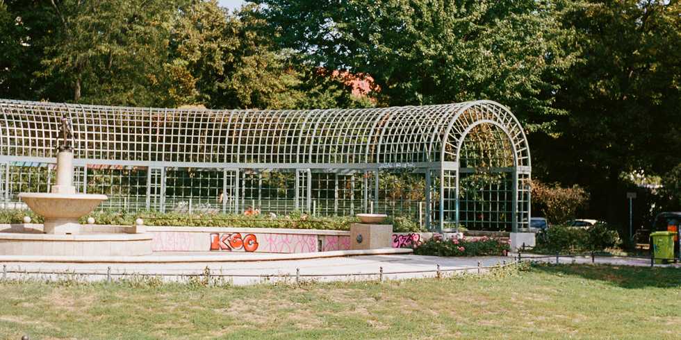 Der Reuterplatz in Berlin mit grünen Lauben und Blumenbeeten. Diese Aufnahme zeigt die Grünflächen in Neukölln, die zur Lebensqualität und Sauberkeit des Bezirks beitragen.