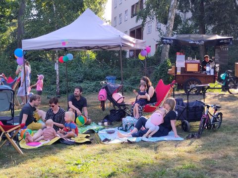 Familien sitzen auf Picknickdecken in einem Park