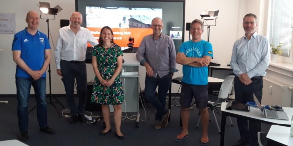 Gerd Thomas (FC Internationale), Norbert Wittke (Obeta), Isabell Strieder (Regionalmanagement), Frank Christian Hinrichs (inno2grid), Tilo Schneider (Croniq), Martin Lind (Druckhaus Mitte) stehen in einem Raum und schauen die Kamera an.