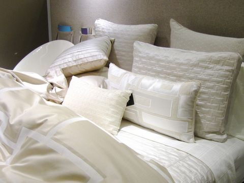 Ein Bett, das mit weißer Bettwäsche bezogen ist