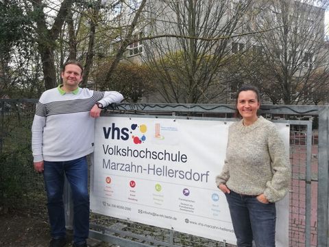 Constanze Paust, Leiterin der FreiwilligenAgentur Marzahn-Hellersdorf und Maik Neudorf, Leiter der Volkshochschule Marzahn-Hellersdorf stehen neben dem Banner der Volkshochschule Marzahn-Hellersdorf