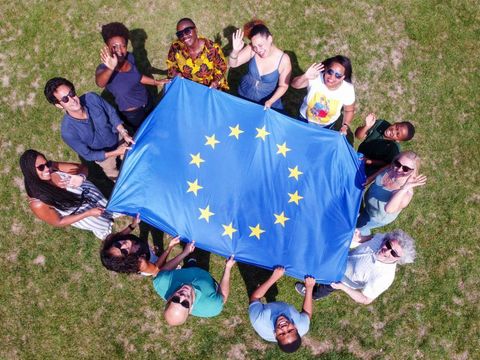 Junge Leute versammeln sich um die EU-Flagge