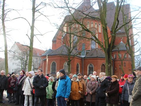 Bildvergrößerung: Menschenversammlung vor einer alten Kirche.