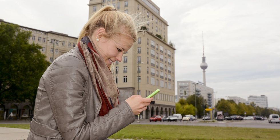 Junge Frau mit Smartphone am Strausberger Platz