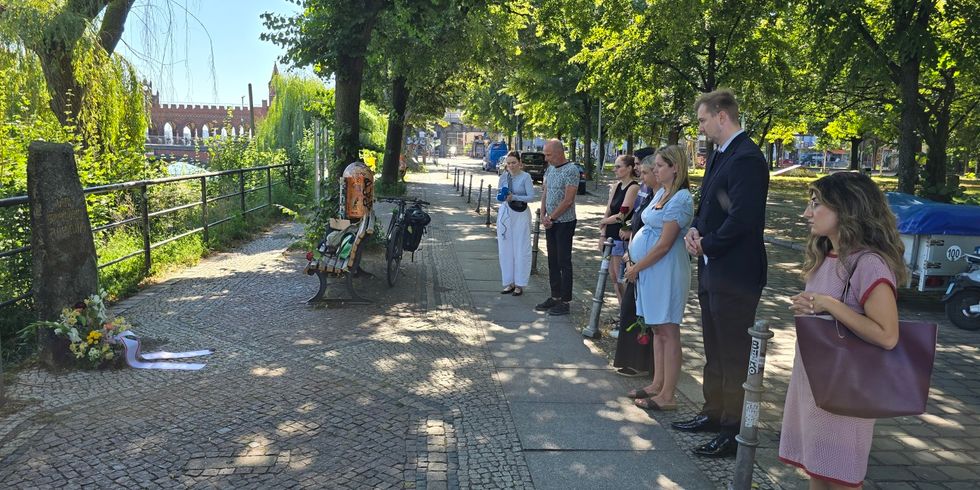 Bezirksstadtrat Max Kindler und der Vorsteher der Bezirksverordnetenversammlung Werner Heck und mehrere Anwesende beim stillen Gedenken am May-Ayim-Ufer in Kreuzberg