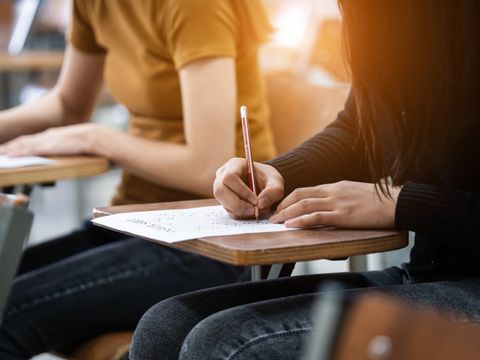 Junge Studierende konzentrieren sich auf die Prüfung im Prüfungsraum. 