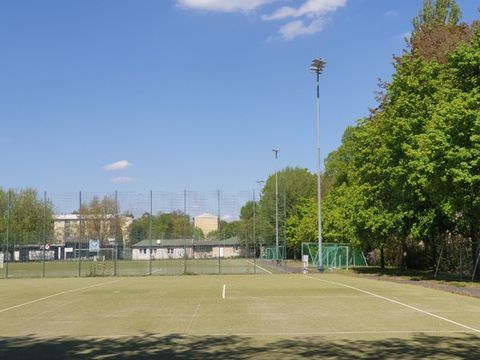 Bildvergrößerung: Am Rande einer begrünten Fläche anliegend ist der Sportplatz mit neuer Beleuchtung am Platzrand.