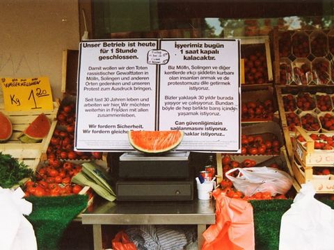 Bildvergrößerung: Vor einem Laden mit Obst- und Gemüsestand draußen steht ein Schild auf dem drauf hingewiesen wird, dass das Geschäft eine Stunde geschlossen bleibt, um den Toten rassistischer Gewalttaten zu gedenken.