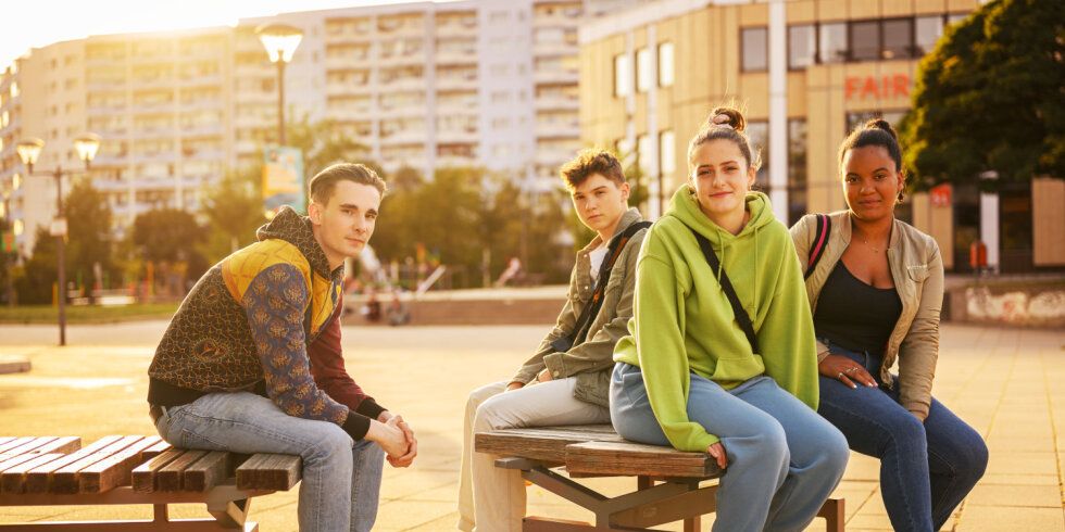 Vier junge Menschen sitzen auf einer Bank