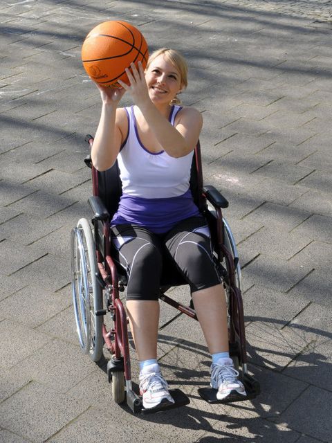 Frau im Rollstuhl spielt Basketball