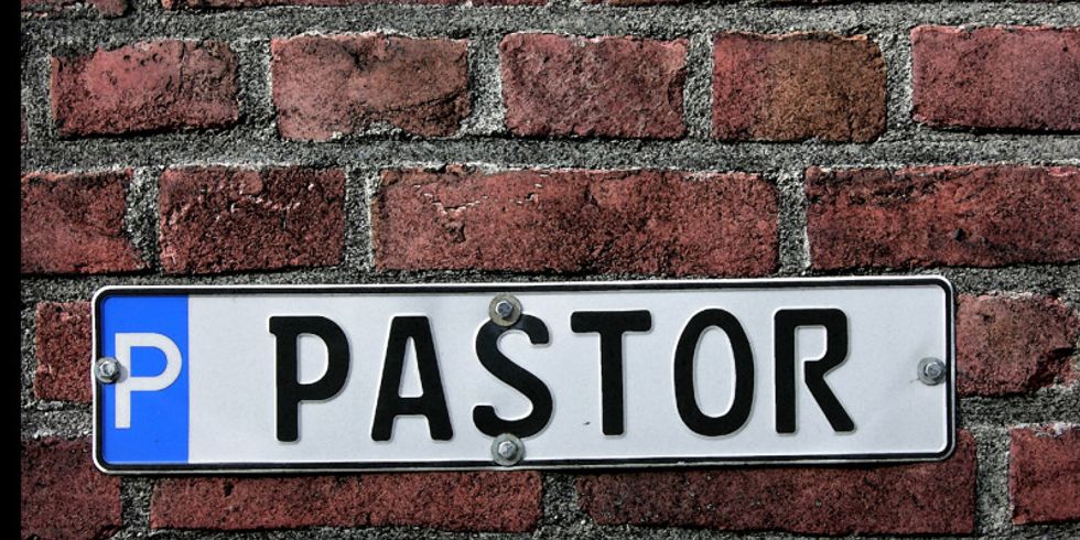 ein Parkplatzschild an einer Mauer mit der Aufschrift "Pastor"