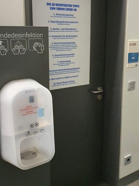 Eingangstür zu den Mannschaftsräumen mit Händedesinfektionsmittel und Hygieneregeln.