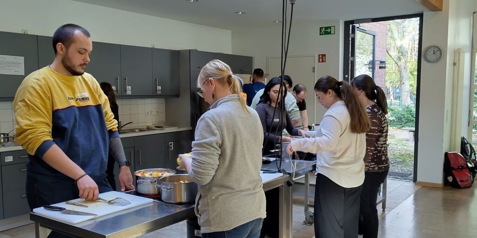 Die Auszubildenden bereiten in der Lehrküche der Volkshochschule ein Drei-Gänge-Menü zu