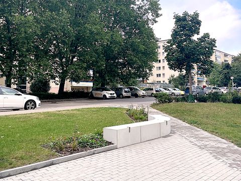 Kleine Platzfläche mit Beet und Betonsitzkante im Wohnstraße