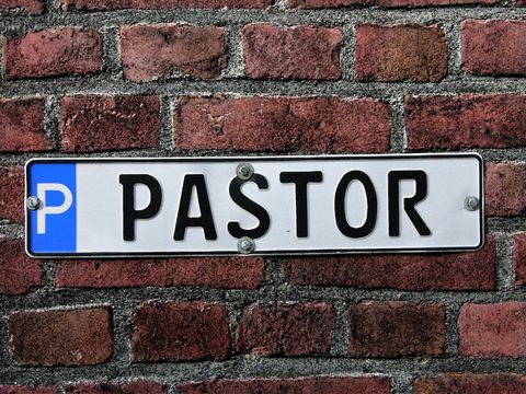 ein Parkplatzschild an einer Mauer mit der Aufschrift "Pastor"