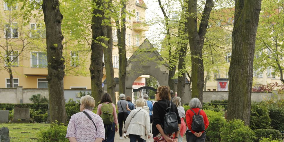 Menschen laufen über einen Friedhof