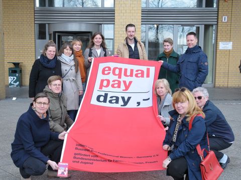 Fahnenhissung zum "Equal Pay Day 2024" - Juliane Witt, Heike Wessoly, Gordon Lemm, Stefan Bley und die Beauftragten Maja Loeffler und Vanessa Krah halten die Fahne