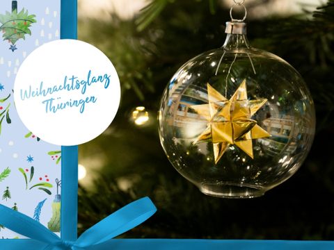 Glaskugel mit Fröbelstern, Schriftzug Weihnachtsglanz Thüringen auf Geschenkpapier