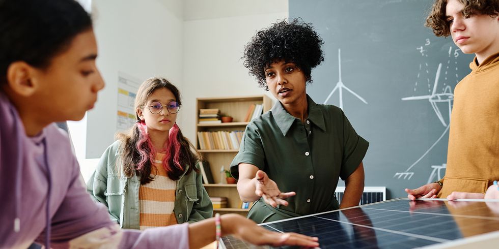 Lehrerin erklärt zwei Schülerinnen ein Solarpanel