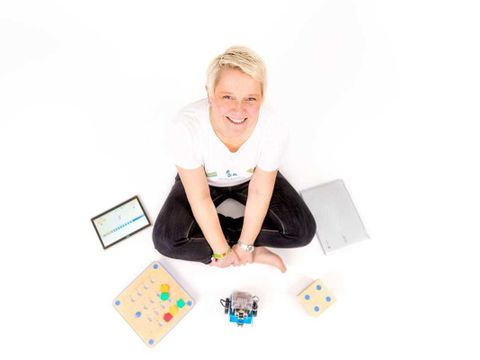 Das Foto zeigt DigitalCoach Kerstin Butenhoff umringt von digitalen und analogen Spielsachen