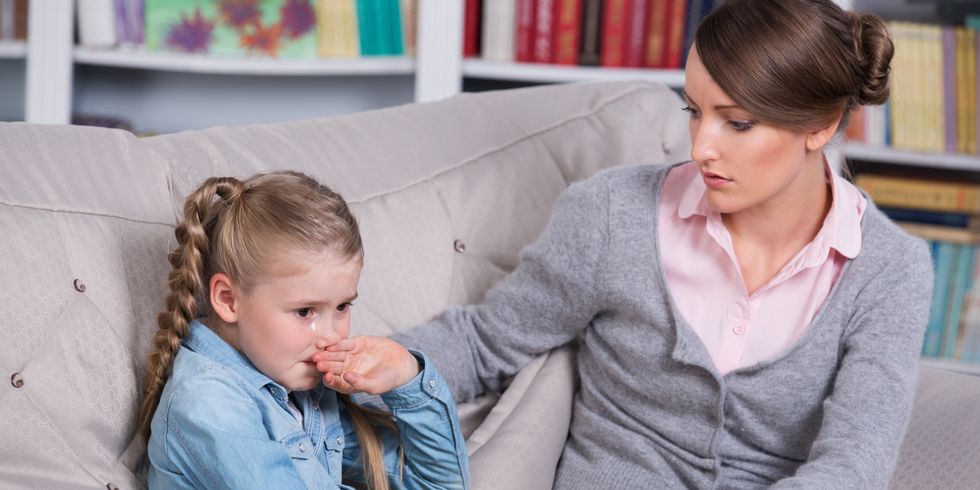 Eine Kinderpsychologin spricht in ihrer Praxis mit einem weinenden Kind