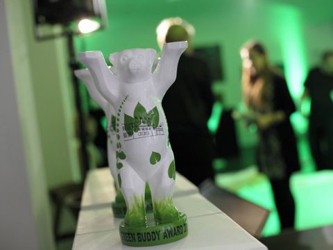 Ein Pokal in Form eines Bären steht auf einem Tisch. Er ist weiß-grün mit Blatt-Motiven und auf dem Sockel steht "Green Buddy Award".