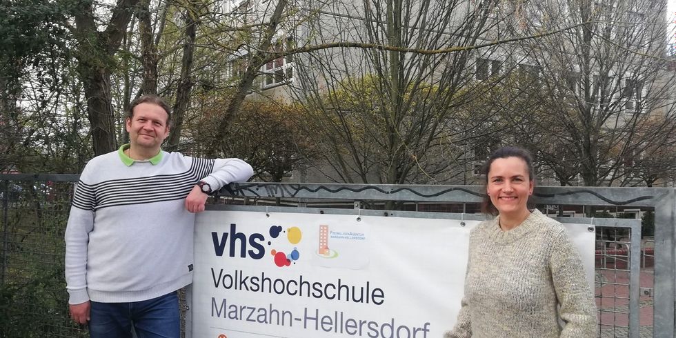 Constanze Paust, Leiterin der FreiwilligenAgentur Marzahn-Hellersdorf und Maik Neudorf, Leiter der Volkshochschule Marzahn-Hellersdorf stehen neben dem Banner der Volkshochschule Marzahn-Hellersdorf