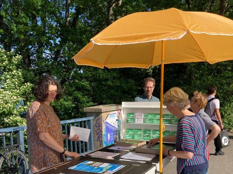 Der mobile Lasstenrad-Infostand der Räume für Beteiligung mit Interessierten und Stadtrat Schmidt im Hintergrund.