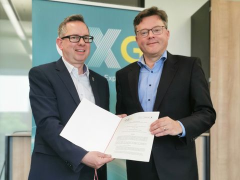 Bezirksbürgermeister Oliver Igel und Dr. Sören Trebst, Geschäftsführer von OXG, halten den gerade unterzeichneten "Letter of Intent" in ihren Händen