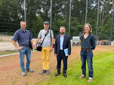 Bitte recht freundlich! Valerii Ponomarenko am 19. Juli 2023 auf der Baseball-Sportanlage, zusammen mit Ulf Elsner (links, Sportstättenplaner), daneben Christian Urlaub (bezirklicher Partnerschaftsbeauftragter) und Annette King (rechts, Vertreterin des Grünflächenamtes)