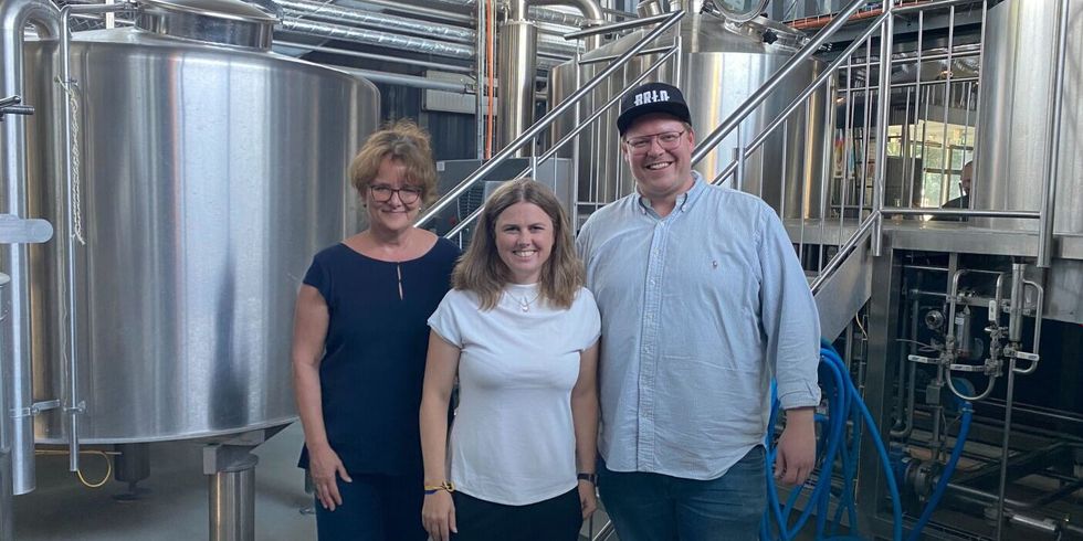 Clara Herrmann, Kathrin Klisch und Ben Pommer von BRLO vor den Braukesseln in der BRLO-Brauerei