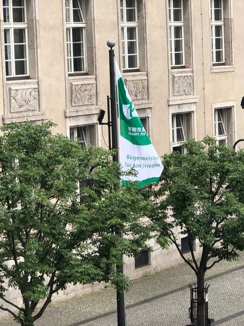 Bildvergrößerung: Die Mayors for Peace - Flagge weht am 8. Juli 2021 auch auf dem Vorplatz des Neuköllner Rathauses