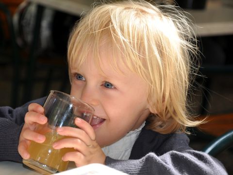 Ein Kind trinkt aus einem Glas Saft