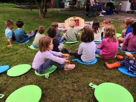 Kinder beim Kamishibai im Garten