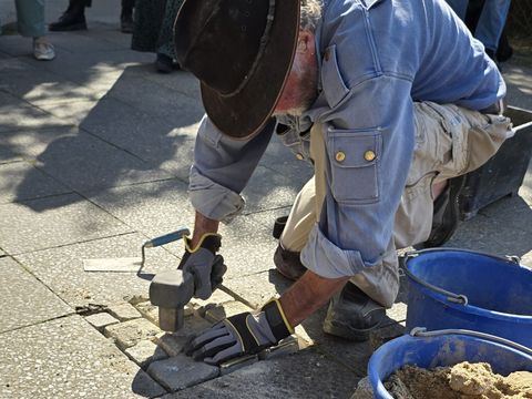 Eine Person verlegt Stolpersteine