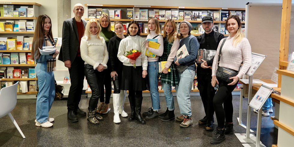 Eine Gruppe von Frauen und Männern im Besuchszentrum der Berliner Landeszentrale: Blumenüberreichung an die 10.000sten Besucherinnen und Besucher des Jahres 2022