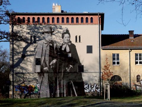 Bildvergrößerung: Auf der Fassade eines Gebäudes ist das Bild von einem Mann und einer Frau in schwarz-weiß.