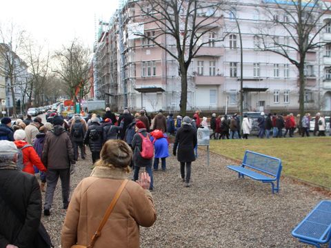 Bildvergrößerung: Menschen laufen auf dem Gehweg in eine Richtung.